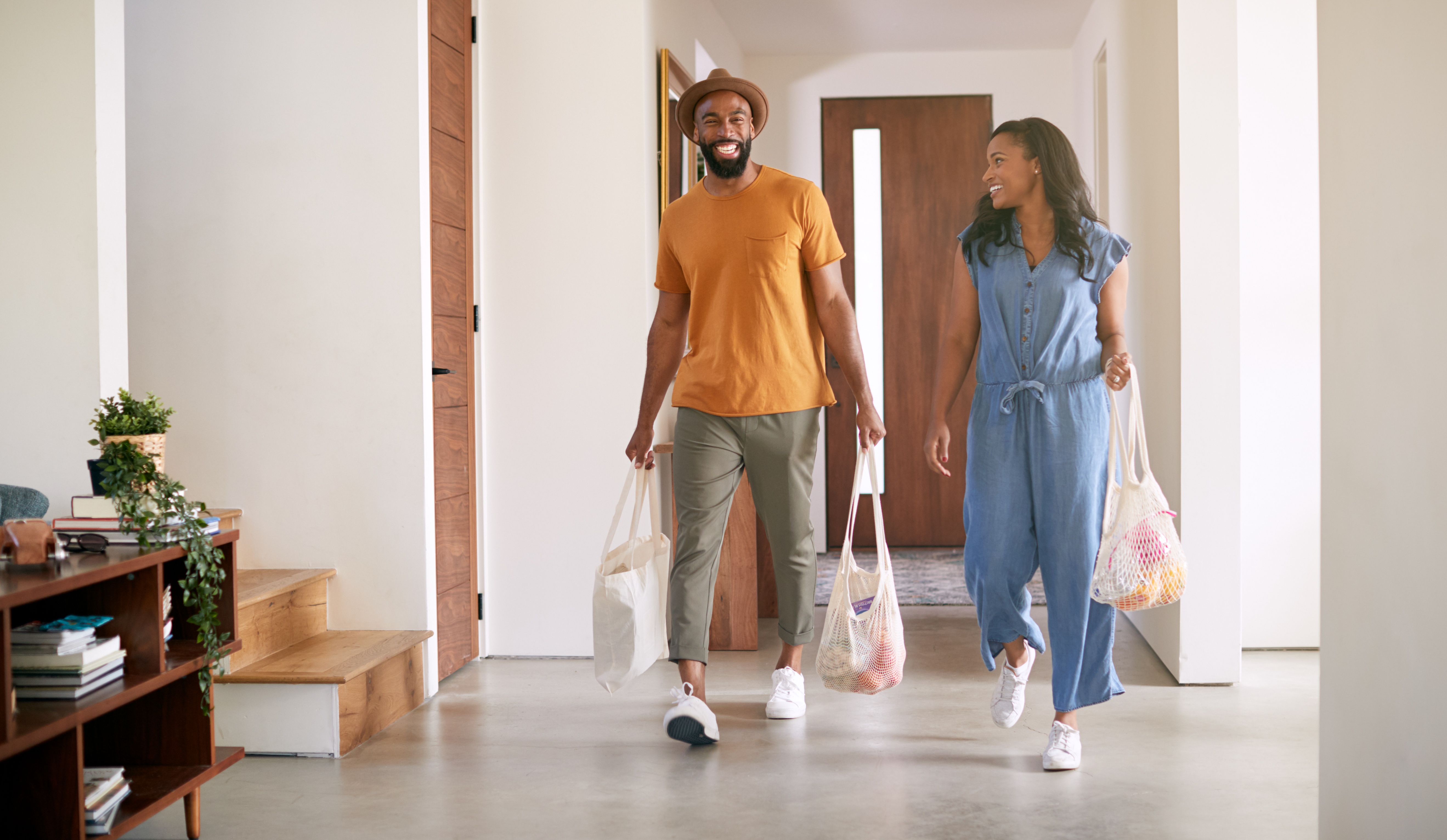 Couple revenant à la maison avec sacs d’épicerie 