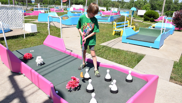 Boy playing mini golf