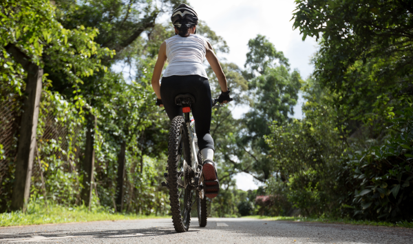 Woman cycling on a trail in a forest