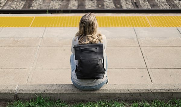 Photo d'une femme de dos portant un sac à dos sur le quai d'une gare