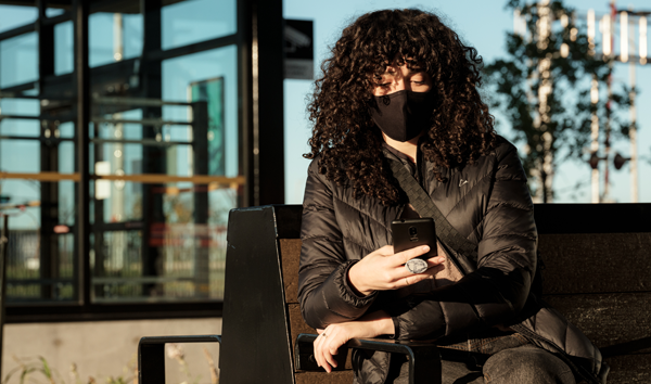 Photos d'une femme portant un masque qui regarde son téléphone