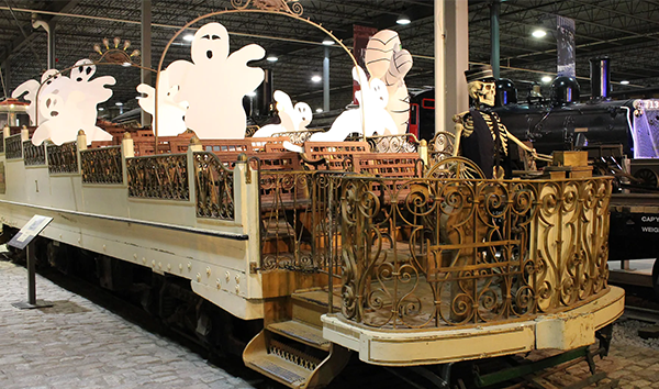 Une vieille voiture de train peuplé de fantôme et conduit par un squelette