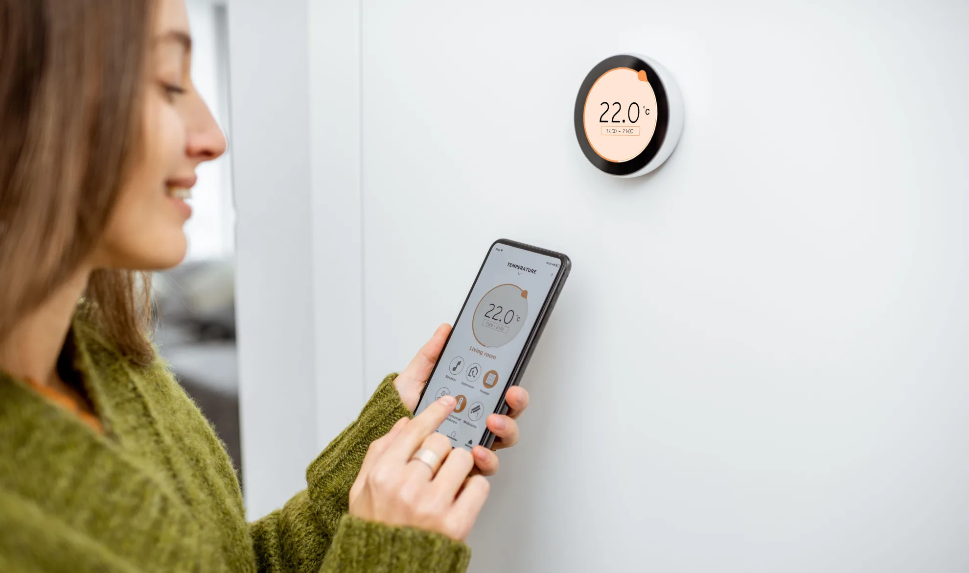 Femme changeant la température avec son téléphone intelligent