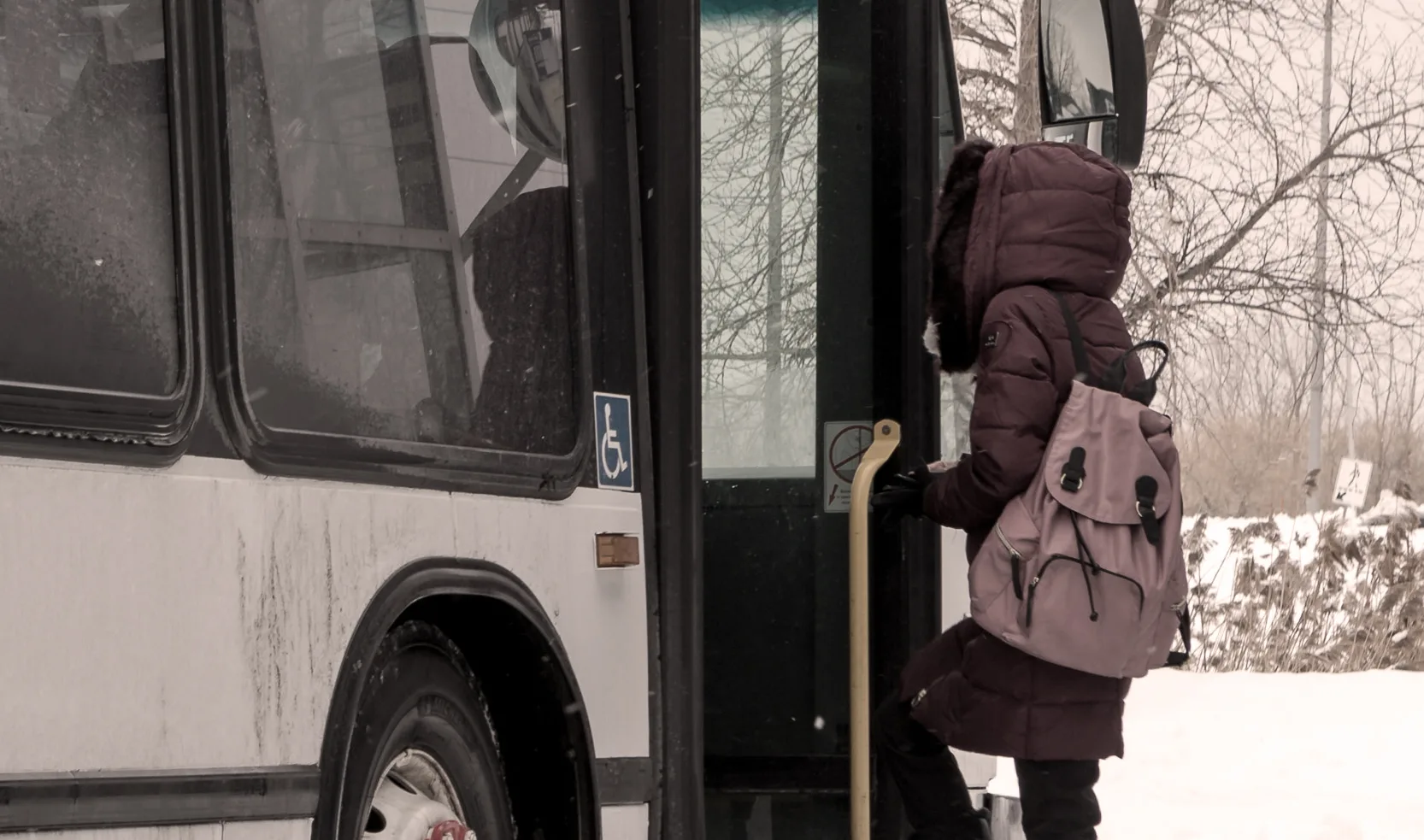 Personne montant dans un autobus en hiver