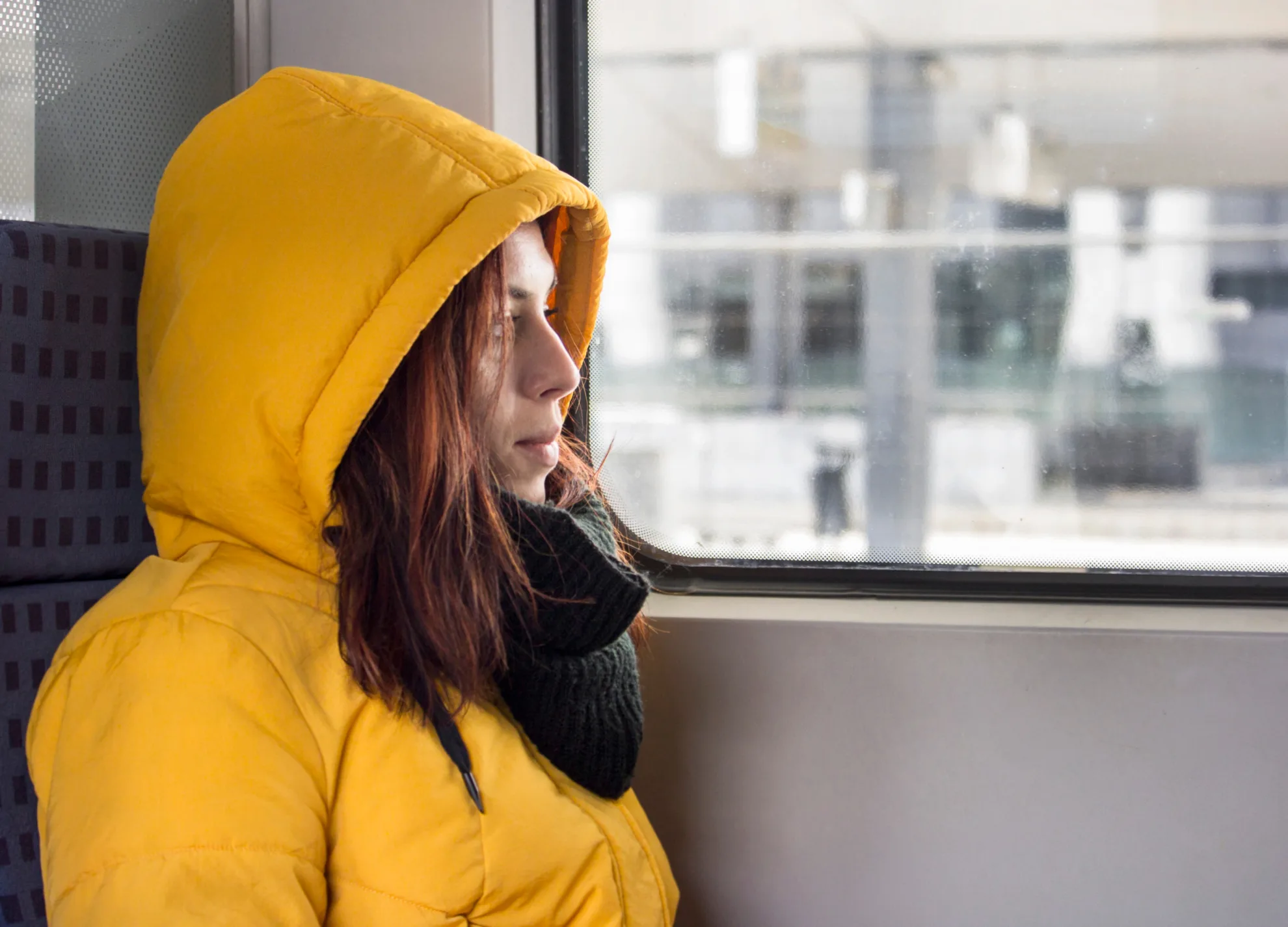 Femme en manteau jaune dans un train