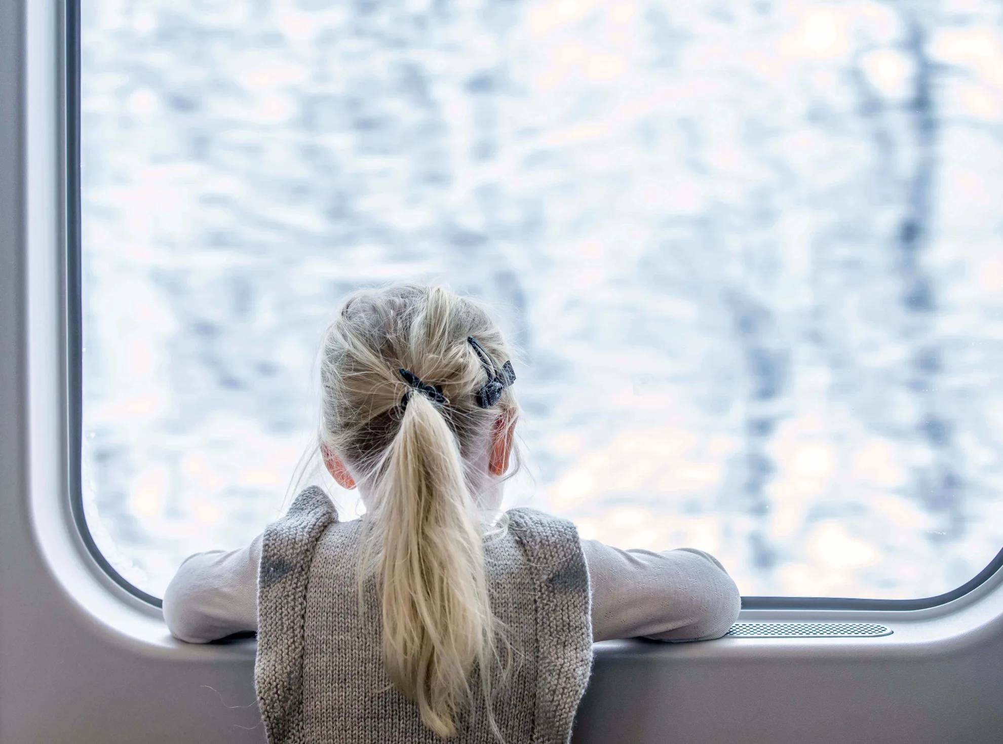 Fille qui regarde le paysage enneigé depuis la fenêtre du train